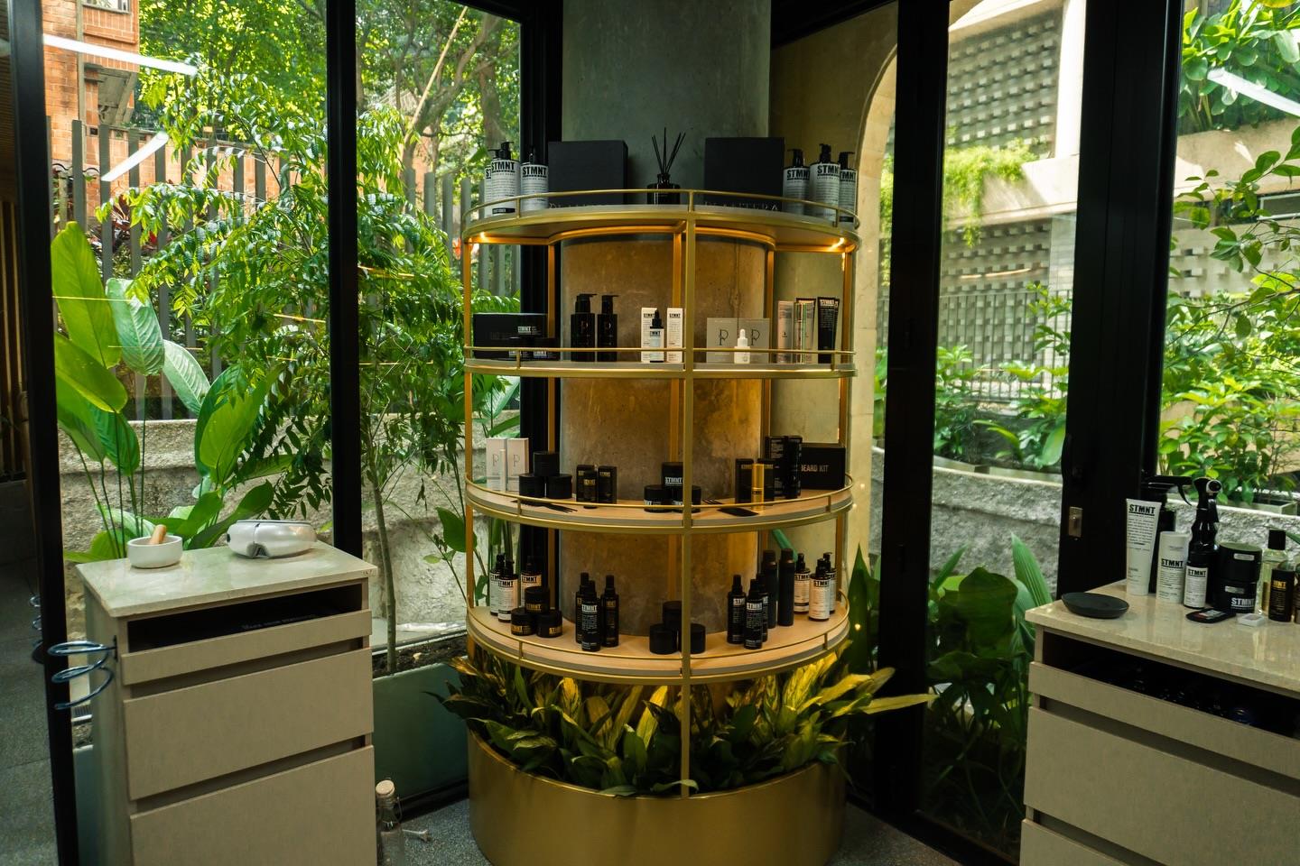 Estante de latón con productos de grooming entre plantas